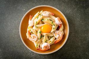 pasta penne salsa de crema blanca con gambas y huevo foto