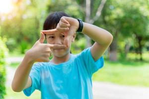 Close up of child girl smiling making frame with hands and fingers. Creativity and photography concept. photo