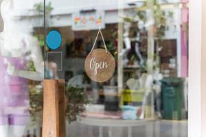 un negocio firmar ese dice abierto en local negocios colgar en puerta a entrada. decir Bienvenido. abierto y cerrado dar la vuelta firmar en frente de tienda vaso puerta. foto