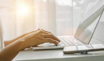 Close up of man hands using laptop at home office. Concept of searching web, browsing information. soft focus photo