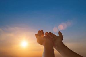 Child open empty hands with palms up for hope on sunset background. Freedom spirituality concept. photo