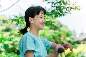 Cheerful child girl playing on playground in the park. Healthy summer activity for children. photo