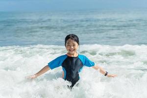 Happy child having fun on summer vacation. Child girl on the beach on sea shore. photo