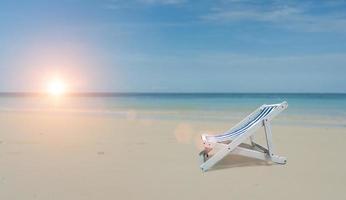 playa silla en mar apuntalar arenoso. playa con azul cielo antecedentes. verano vacaciones concepto. Copiar espacio para texto foto