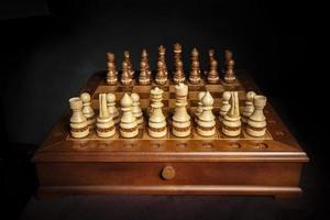 Chess pieces of wood on a beautiful chessboard. A puzzle game with tricky combinations that requires planning and thinking. photo