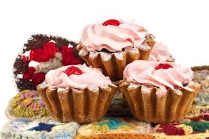 Beautiful sweets. Cakes basket with pink cream decorated with red berries. photo