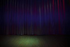 Green dark stage floor and dark purple curtains. photo