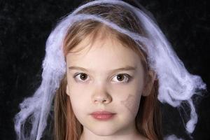 Little girl on the halloween spider web. photo