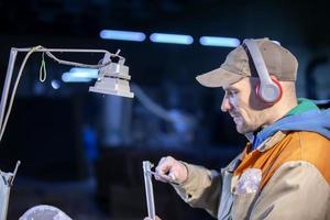 A worker in the furniture industry measures a metal profile with a caliper. photo