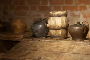 Retro jugs and a barrel in an old brick basement. photo