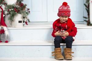 Happy little boy in christmas. Funny child on the porch of the Christmas house. photo