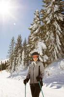 joven mujer disfrutando invierno día de esquiar divertido en el nieve foto