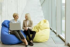 Businesswomen using laptop computer on lazy bags in the modern office photo