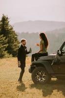 Young couple relaxing on a terrain vehicle hood at countryside photo