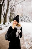 Young woman with Warm Clothes in Cold Winter Snow drinking coffee to go photo