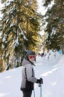 Young woman enjoing winter day of skiing fun in the snow photo