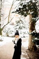 Young woman with Warm Clothes in Cold Winter Snow drinking coffee to go photo