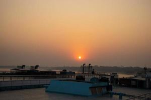 Beautiful Dawn with a sunrise view on a ship. Twilight view with sunset and water vessel. Beautiful sunset view on a ship at dusk time. Sky and tree horizon with sunrise scenery from a launch. photo