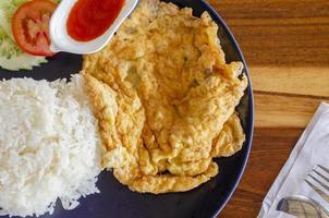 Omelet rice on wooden table, Thai Breakfast,  top view photo