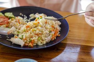 seafood fried rice, asian woman eating, popular thai food photo