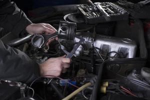 Car engine maintenance. Engine piston system repair. Hands with a mechanic with a caliper measure the size of the piston. photo