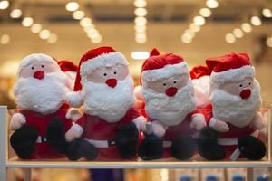 Many Santa Claus toys in a store window. Christmas sale of souvenirs. photo
