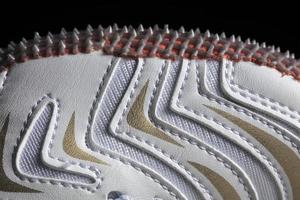 Part of a white sneaker with a sole on a dark background. Macro fragment of sports shoes photo