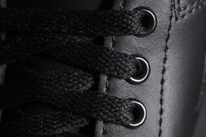 parte de un negro bota con cordones un fragmento de oscuro zapatos. un pedazo de zapatilla de deporte foto