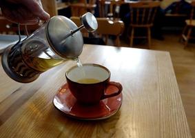 francés prensa bebida siendo vertido dentro un taza foto