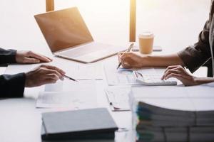 Financial analysts analyze business financial reports on a digital tablet planning investment project during a discussion at a meeting of corporate showing the results of their successful teamwork. photo