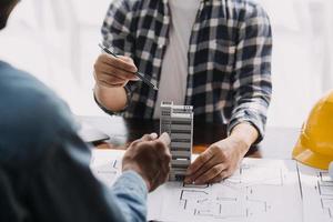 Image of engineering objects on workplace with three partners interacting on background photo