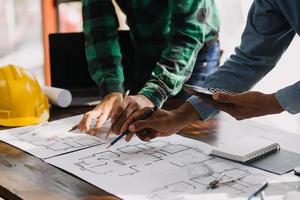 Image of engineering objects on workplace with three partners interacting on background photo