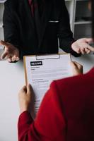 Close up view of job interview in office, focus on resume writing tips, employer reviewing good cv of prepared skilled applicant, recruiter considering application, hr manager making hiring decision photo
