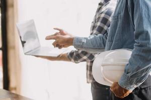 Image of engineering objects on workplace with three partners interacting on background photo