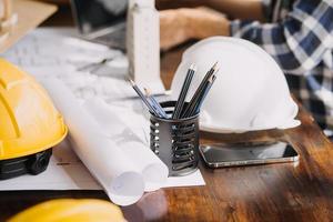 Image of engineering objects on workplace with three partners interacting on background photo