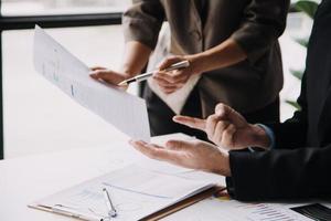 Financial analysts analyze business financial reports on a digital tablet planning investment project during a discussion at a meeting of corporate showing the results of their successful teamwork. photo