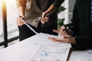 Financial analysts analyze business financial reports on a digital tablet planning investment project during a discussion at a meeting of corporate showing the results of their successful teamwork. photo