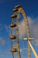 ferris rueda en el diversión parque en antecedentes de azul cielo con nubes bajo ángulo ver de un grande ferris rueda. foto