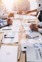 Financial analysts analyze business financial reports on a digital tablet planning investment project during a discussion at a meeting of corporate showing the results of their successful teamwork. photo