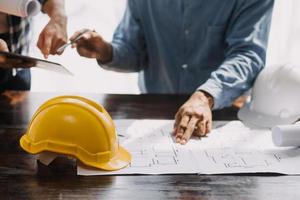 Image of engineering objects on workplace with three partners interacting on background photo