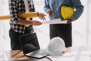 Image of engineering objects on workplace with three partners interacting on background photo