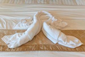 Clean white bath towels on the hotel bed photo