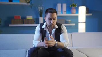 Stressed and worried young business man looking at watch in dark home room, nervous anticipation video