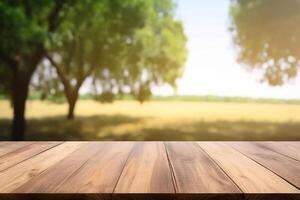 Empty wood table with free space, tree leaves on both sides, blurred farm in background. photo