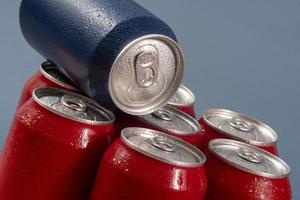 Cold red soda cans with a blue one for conceptual use photo