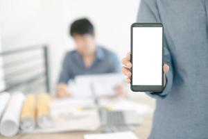 Mockup image of engineers showing smartphone design building Project in office, mockup concept photo