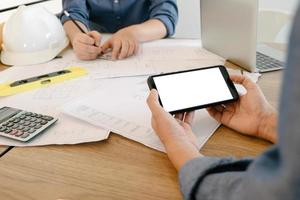 Mockup image of engineers using smartphone to drawing design building Project in office, mockup concept photo