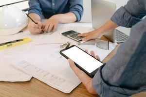 Mockup image of engineers showing smartphone design building Project in office, mockup concept photo