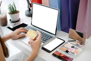 Mockup image of beautiful woman holding credit card enjoying in shopping website online with smartphone and laptop, mockup concept photo