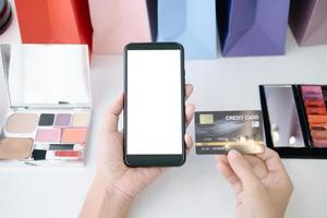 Mockup image of Beautiful woman holding credit card shopping online with smartphone on online websites, mockup concept photo